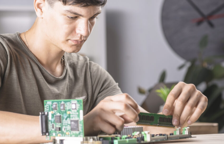 male it technician inserting ram memory computer motherboard Saravati